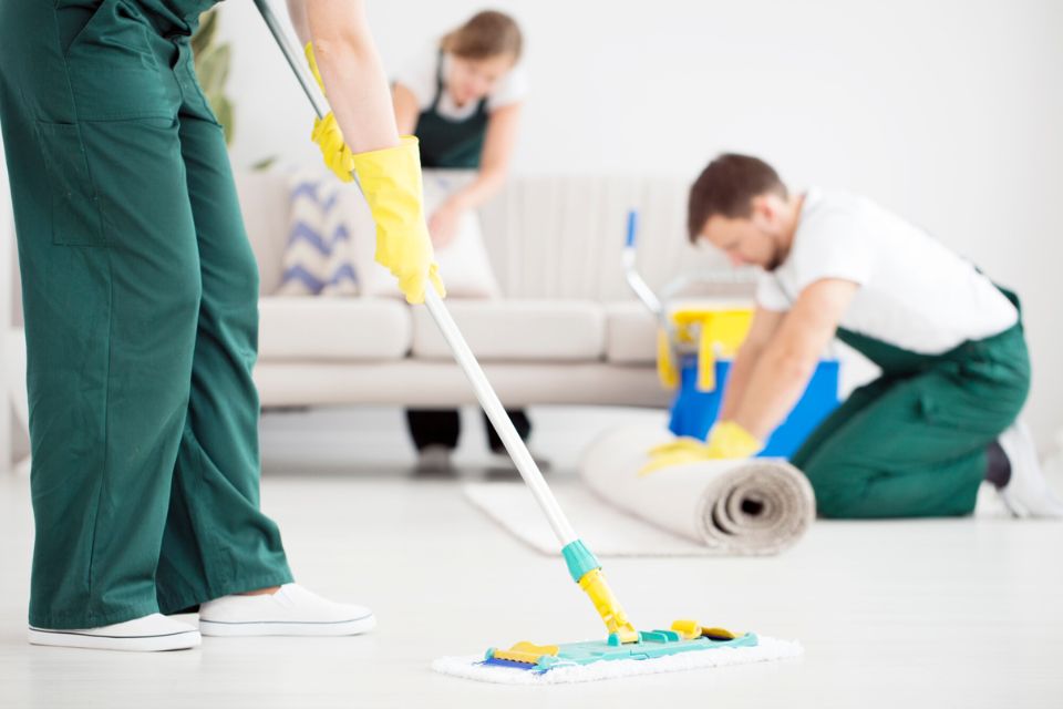 A man and woman mopping a room, illustrating a carpet cleaning service based in Washington, DC.